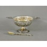 A Continental silver bowl, embossed, with cast lug handles, and a spoon