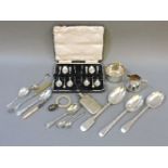 A boxed set of six silver teaspoons and sugar tongs, a silver caddy spoon, a silver teaspoon,