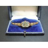 A ladies 9ct gold mechanical bracelet watch, with pink and blue spandrels to a rectangular case,