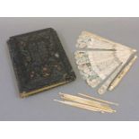 A 19th century ivory fan, a bodkin case, a quantity of crochet hooks, and an illuminated book