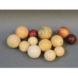 A Victorian collection of thirteen natural and stained ivory billiard balls