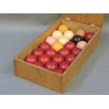 A Victorian set of twenty-four ivory billiard balls, stained and natural