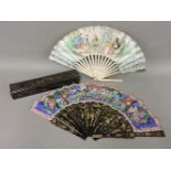 A Chinese export lacquered fan, worn fixing detached, in a box, together with a lithographed and