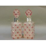 A pair of silver coloured cut glass scent bottles