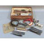 A case of collectable items, including pipes and penknives