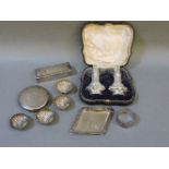 A cased set of silver cruets, four silver salts in the form of shells, a silver pin dish, silver