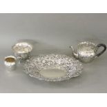 A pierced silver dish, small teapot, milk jug, and sugar bowl