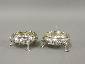 A pair of George III silver salts, initials possibly W C, London 1774, repoussé with flowers on