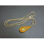 A gold mounted amber pendant, on a 9ct gold Brazilian snake chain