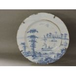 A mid 18th century Delft dish, painted with figures on a punt, 33.5cm diameter