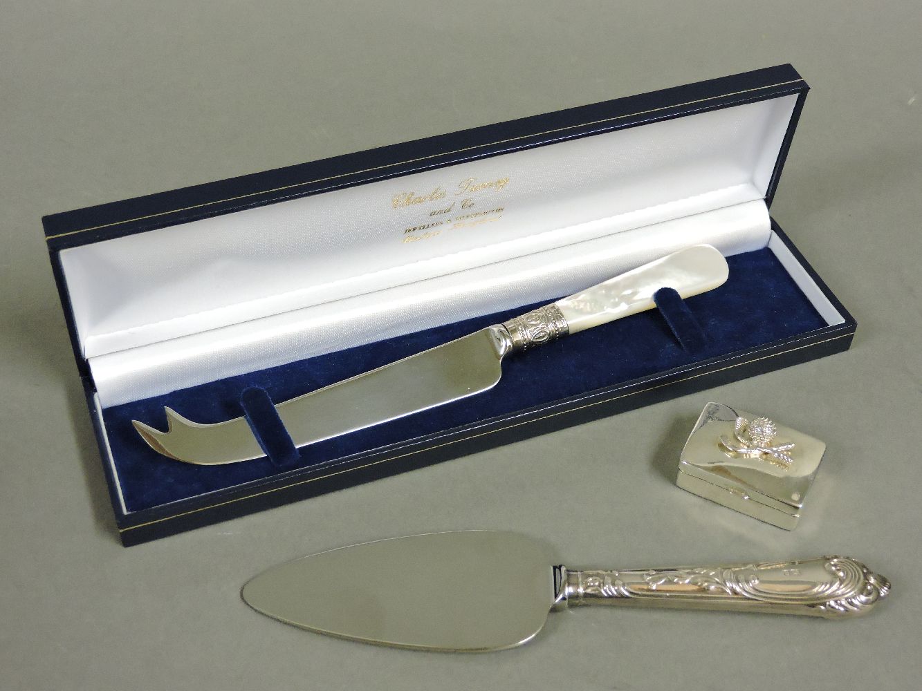 A modern boxed cheese knife, with a silver collar and mother of pearl handle, a modern cake slice