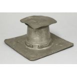 A Liberty's Tudric pewter inkwell,designed by Archibald Knox, the square cover bent, with a glass