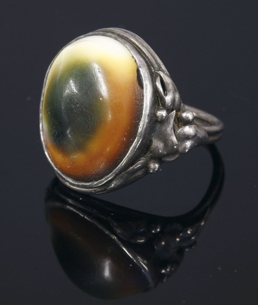 An Arts and Crafts silver operculum ring,with applied leaf and bead shoulders to a double wire