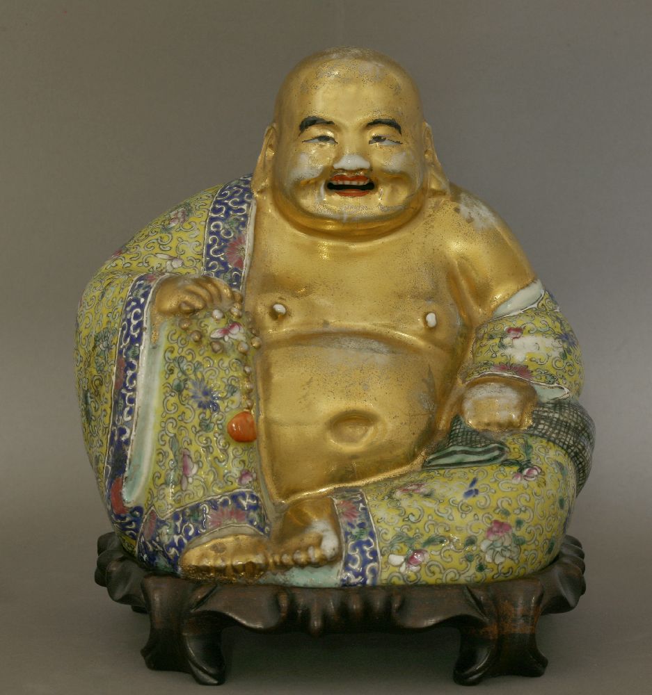 A famille rose Budai, 20th century, wearing a yellow ground garment painted with florets amongst