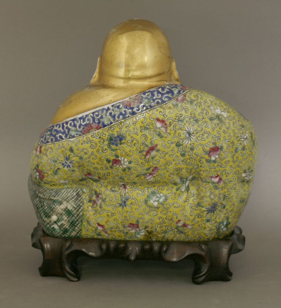 A famille rose Budai, 20th century, wearing a yellow ground garment painted with florets amongst - Image 2 of 2