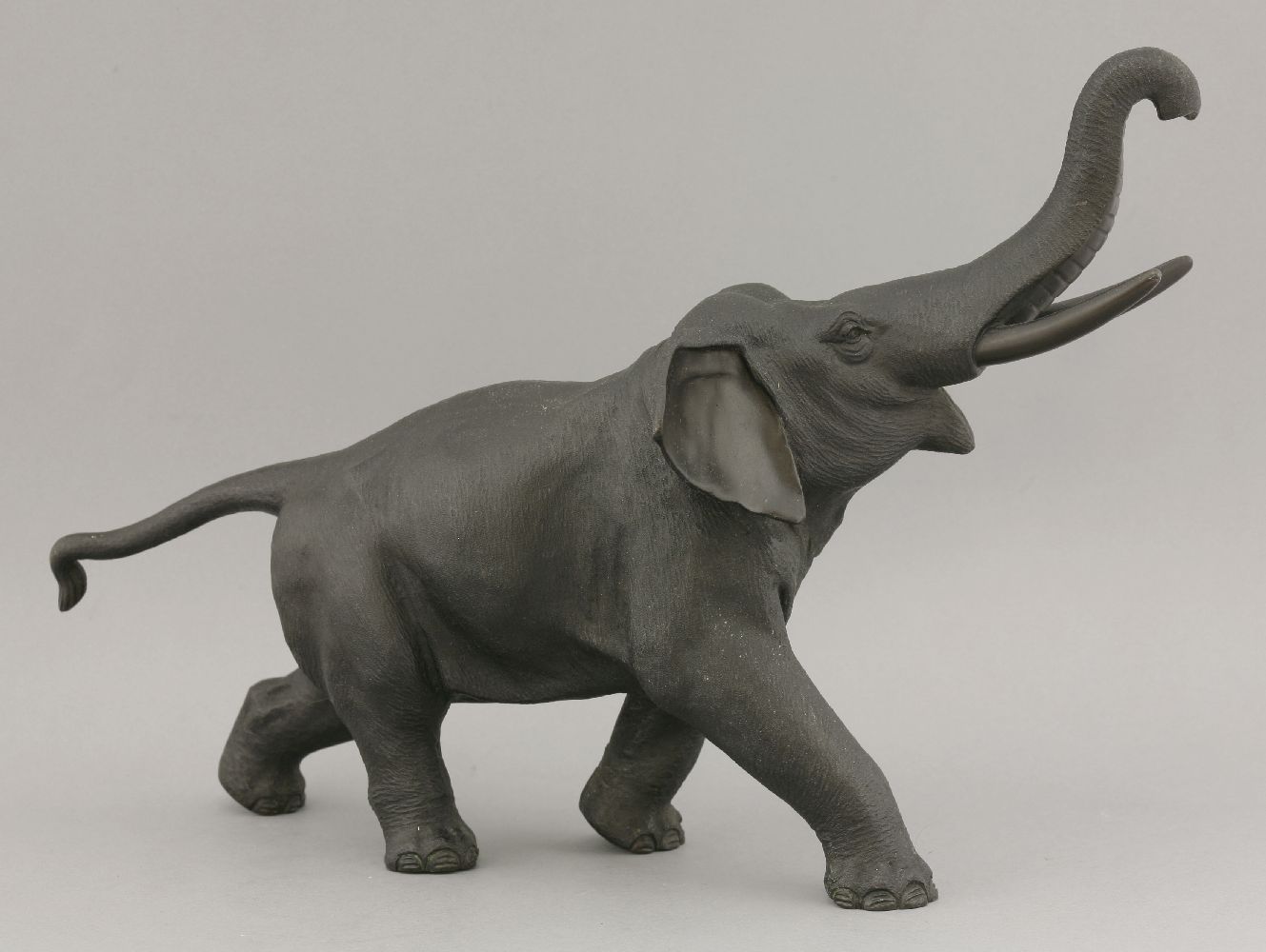 A bronze Elephant,c.1880, striding forward with trunk upraised and with typical rough skin, cast - Image 2 of 4