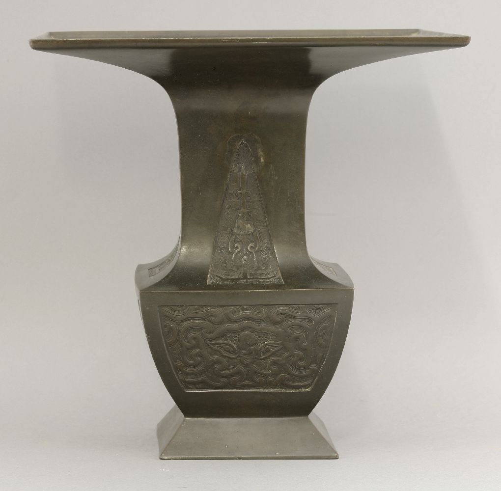 A bronze Ikebana Vase,c.1900, of square section, the neck with archaic blade panels above taotie,