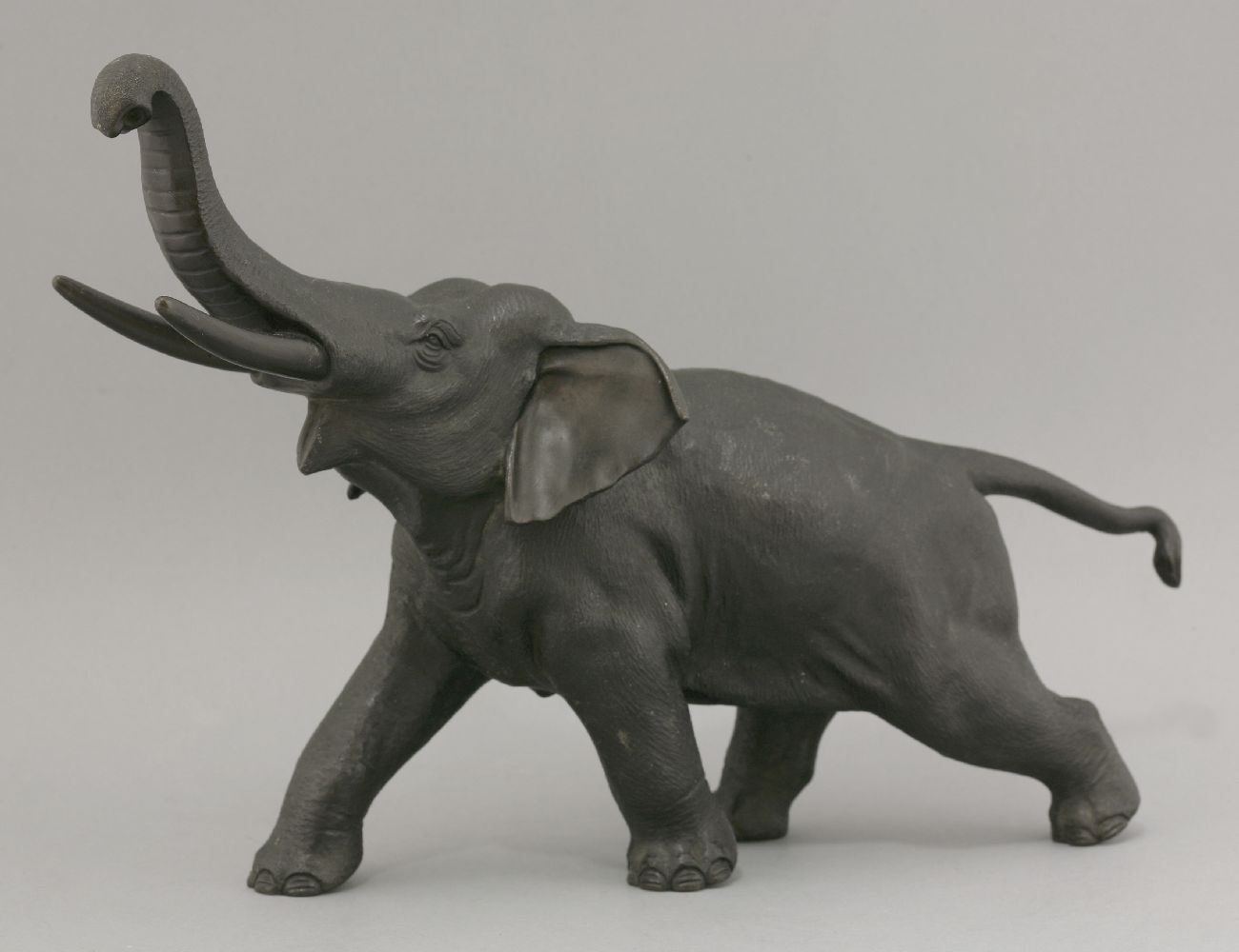 A bronze Elephant,c.1880, striding forward with trunk upraised and with typical rough skin, cast