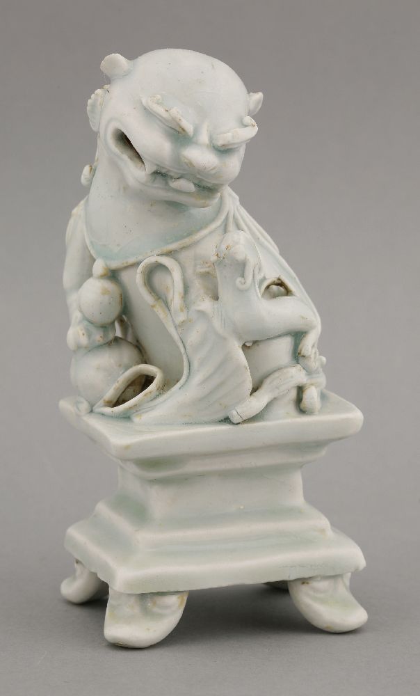 A rare qingbai Buddhist Lion and Cub,Yuan dynasty (1279-1368), the smiling beast looking down at its