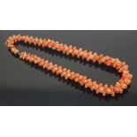 A Victorian salmon pink carved coral necklace,with graduated, waisted beads with half bead ends, all