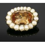 A Georgian topaz and split pearl gold brooch, c.1800,with an oval mixed cut topaz, possibly