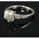 An 18ct white gold, single stone diamond ring, with baguette cut diamond shoulders.  An old European