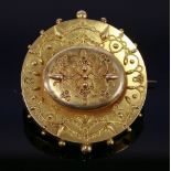 A late Victorian gold Etruscan-style circular shield brooch,with a raised central oval boss,