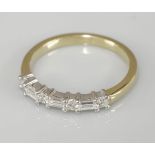 An 18ct yellow and white gold baguette cut diamond and brilliant cut diamond half eternity ring