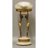 A gilt metal and alabaster table lamp, modelled as two nudes holding a saucer shaped shade, on a