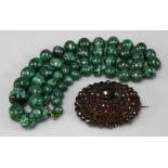 A Bohemian cabochon and rose cut garnet oval cluster brooch, and a single row graduated malachite