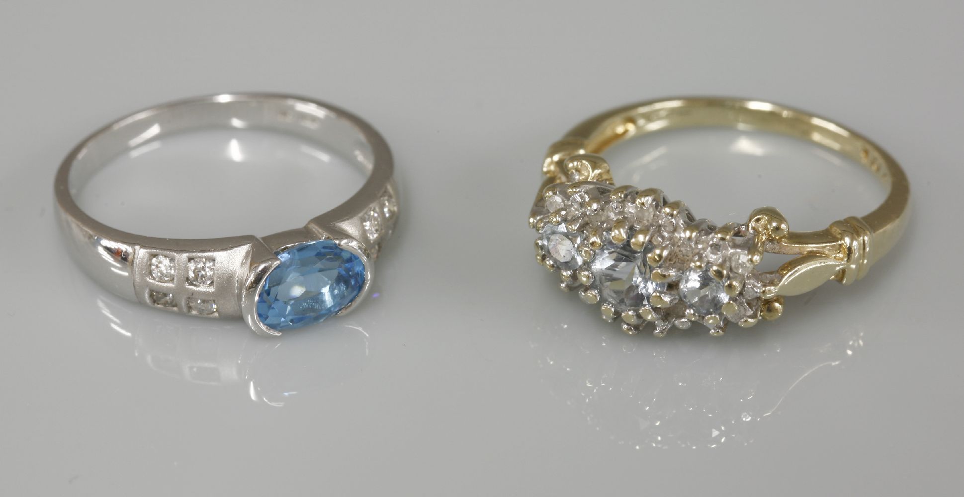 A 9ct gold aquamarine and diamond regal cluster ring, and a 9ct white gold single stone blue topaz