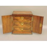 A rosewood cabinet, of small proportions, with three interior drawers and campaign handles