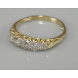 A five stone graduated diamond carved head ring, tested as approximately 18ct gold