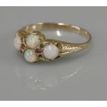 A late Victorian four stone opal ring, with gemstone points, tested as approximately 15ct gold