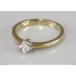 An 18ct gold single stone princess cut diamond ring, claw set in an off set position