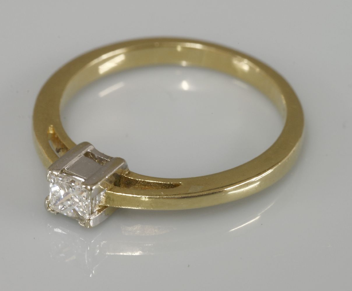 A single stone princess cut diamond ring, marked 750