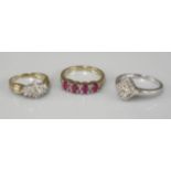 A 9ct gold ruby and diamond half hoop ring, a 9ct white gold lozenge shaped diamond cluster ring,