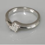 An 18ct white gold single stone princess cut diamond crossover ring