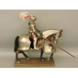 A model of a knight dressed in full armour, with lance, on resin horse also dressed in armour, of