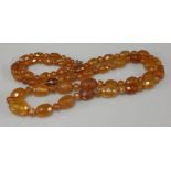 A single row graduated faceted olive shaped amber bead necklace, with faceted amber rondelle