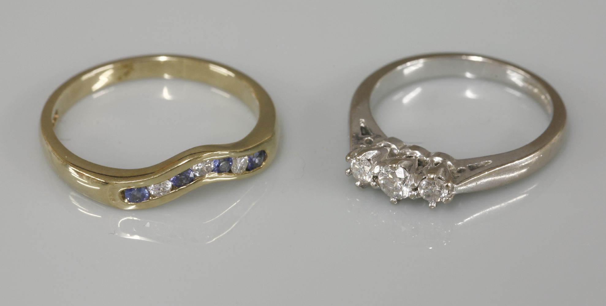 An 18ct white gold three stone diamond ring, and a 9ct gold sapphire and diamond half wishbone