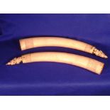 A pair of large late 19th/early 20th Century carved Elephant Ivory Tusks, each surmounted with a