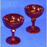 A pair of unusual Victorian ruby glass Champagne Glasses of saucer shape and having slice cut stems,