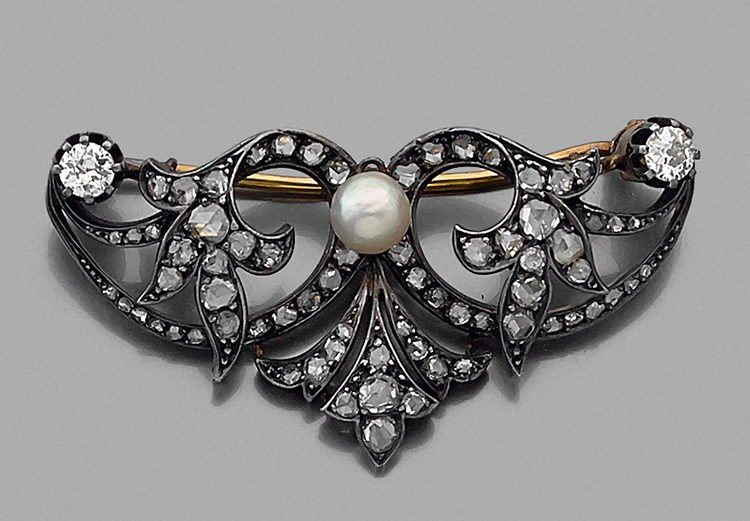 ANNÉES 1860BROCHE VOLUTEen or et argent. Au centre une perle fine sur un pavage de diamants taille