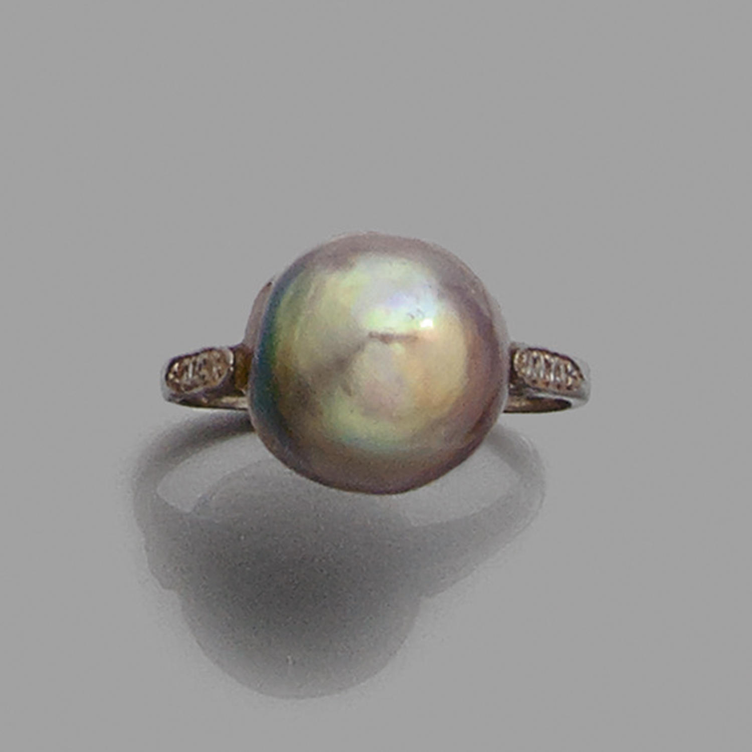 BAGUE PERLE FINEElle est ornée d'une perle bouton de ton mordoré. Monture en or gris rehaussée de