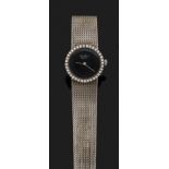 JEAN PERRET GEN ÈVE VERS 1970 Montre bracelet de dame en or gris. Boîtier rond avec lunette sertie