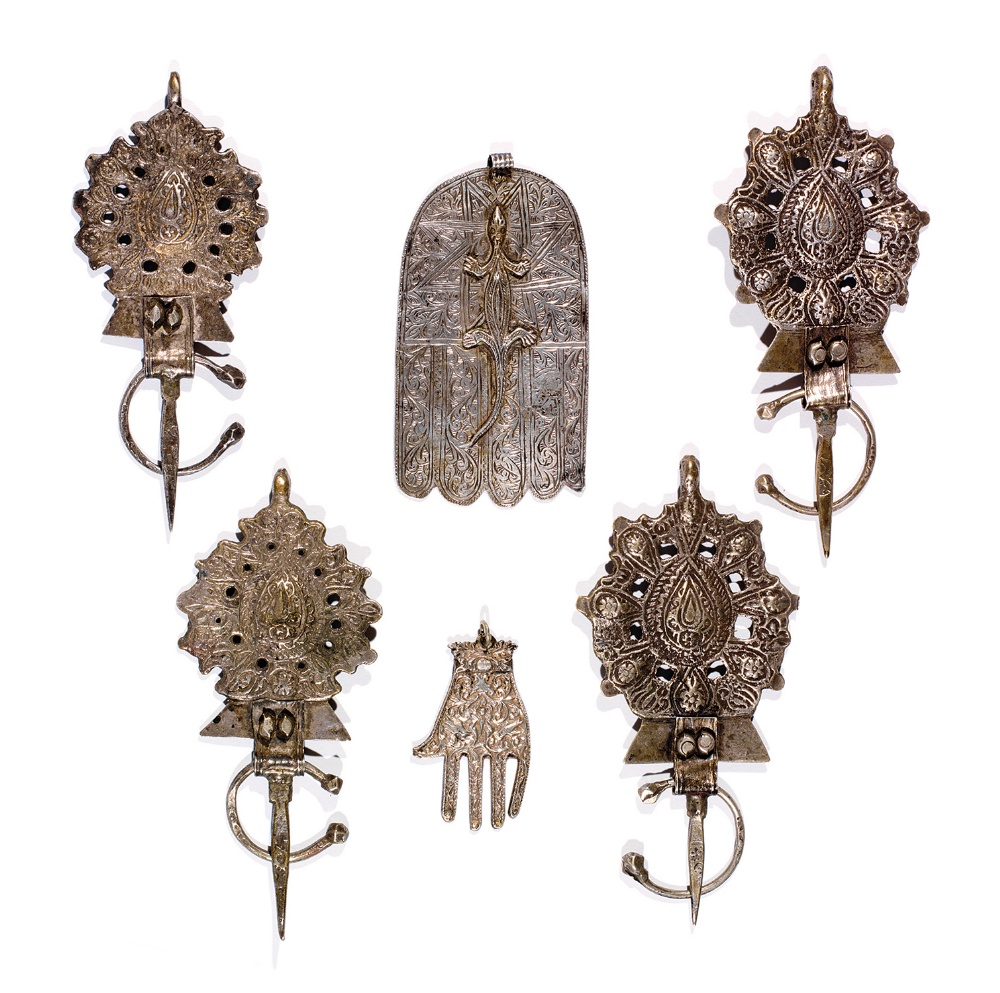 LOT DE DEUX PAIRES DE FIBULES ET DEUX HAMSA MAROCAINES les premières, moulées, ajourées, à décor