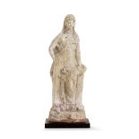 STATUETTE VOTIVE En terre cuite beige représentant une jeune femme vêtue d'un chiton long laissant