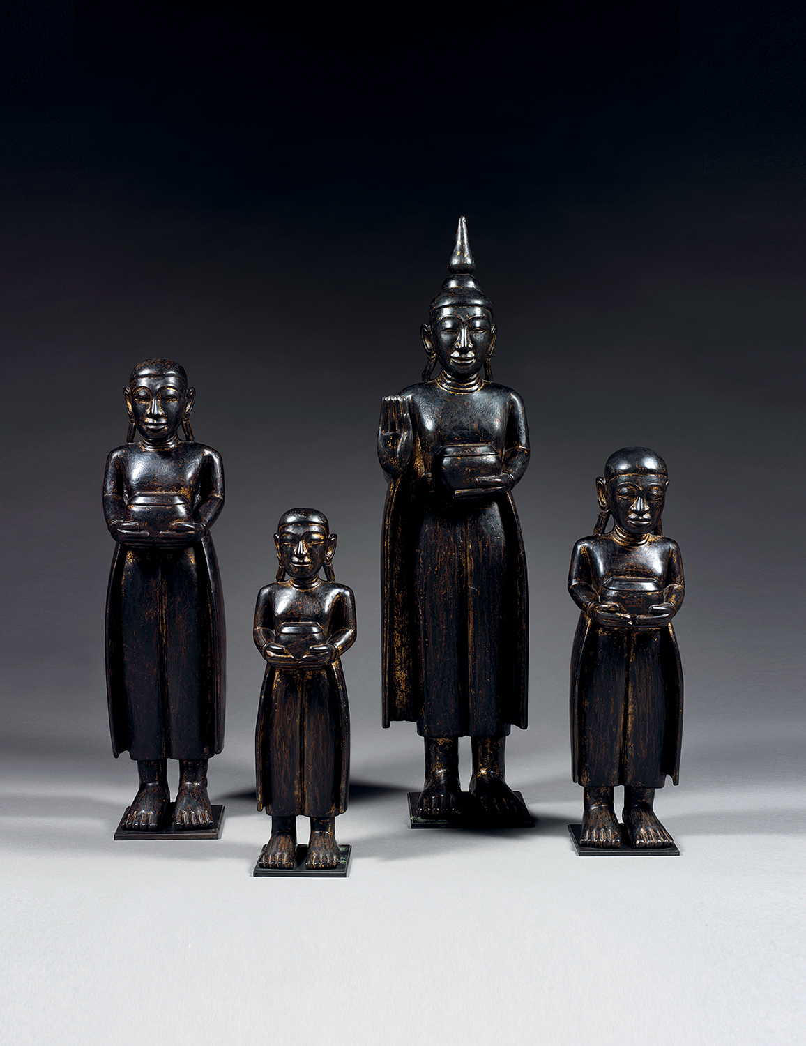 SUITE DE QUATRE STATUES REPRÉSENTANT LE BOUDDHA ACCOMPAGNÉ DE TROIS DISCIPLESEn bois de tek laqué