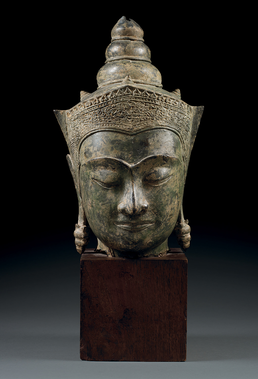 GRANDE TÊTE DE BOUDDHA En bronze de patine brun-vert, les yeux mi-clos en méditation, l'arcade